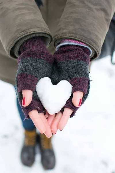 Mulher mãos segurando coração em forma de bola de neve — Fotografia de Stock