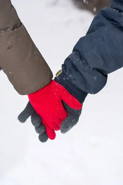 Пара держащихся за руки в заснеженном парке — стоковое фото