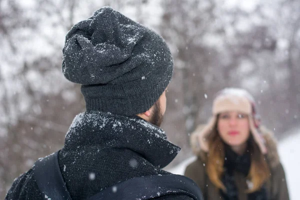 Pareja mirándose mientras está nevando — Foto de Stock