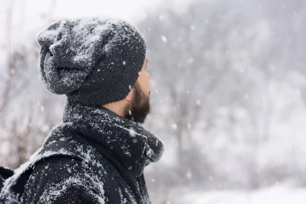 Man standing in a park while snows — Stock Photo, Image