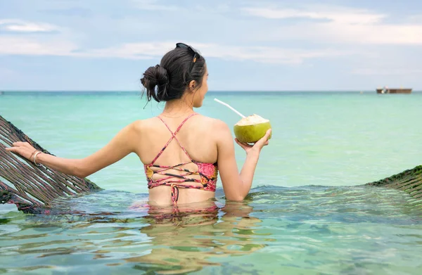 Woman enjoys coconut in the seaside — Stock Photo, Image