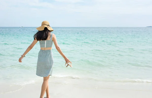Woman walking towards the sea water — Stock Photo, Image