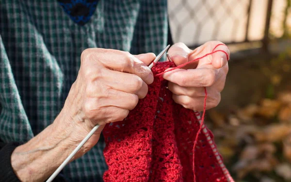 Senior kobieta ręce dziewiarskie z czerwony wełny — Zdjęcie stockowe