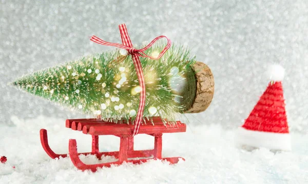 Red sleigh carrying a small Christmas tree — Stock Photo, Image