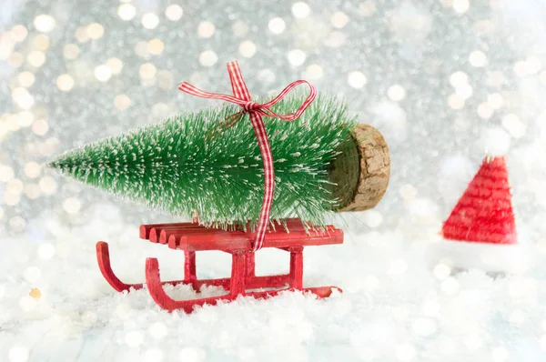 Rode slee uitvoering van een kleine kerstboom — Stockfoto