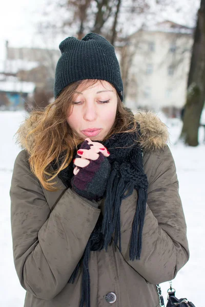 Woman warming hands in snow covered park — Stock Photo, Image