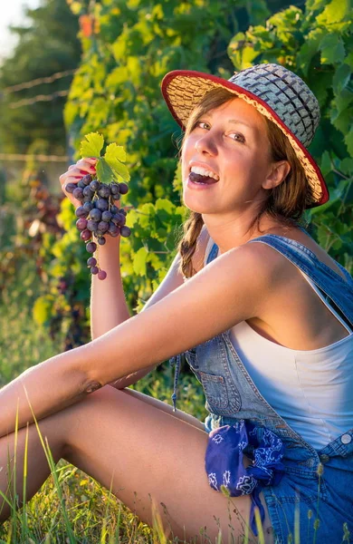 Mujer feliz comiendo uvas en el viñedo —  Fotos de Stock