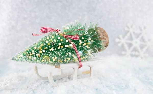 Pequeno trenó carregando uma miniatura de árvore de Natal — Fotografia de Stock