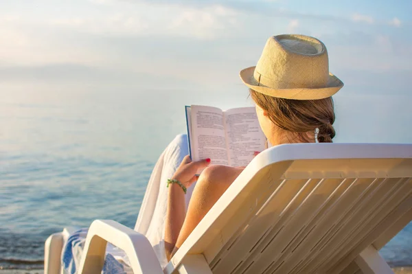 Meisje het lezen van een boek in de zonnebank — Stockfoto