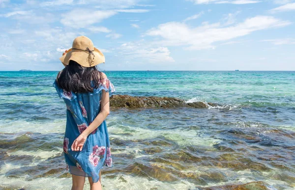 Girl standing in the sea wearing blue dress. — Stock Photo, Image