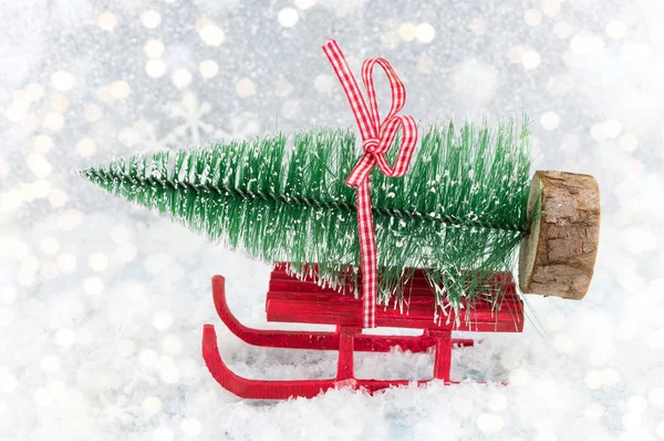 Traîneau rouge portant un petit sapin de Noël — Photo