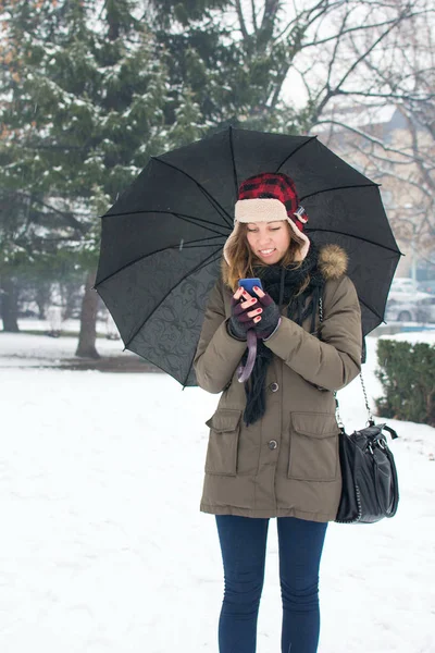 Mulher escrevendo mensagem de texto no inverno — Fotografia de Stock