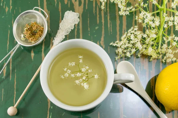 Elderflower tea in white cup and elder flowers — Stock Photo, Image