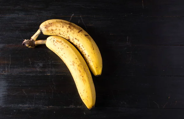 Два банана на темном фоне — стоковое фото