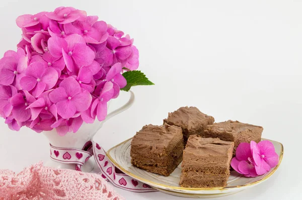 Bunch of hortensia pink flowers and a cake — Stock Photo, Image