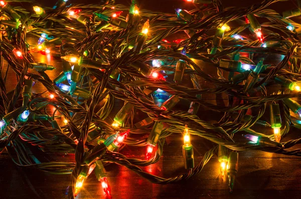 Luzes de Natal enroscadas em uma mesa — Fotografia de Stock
