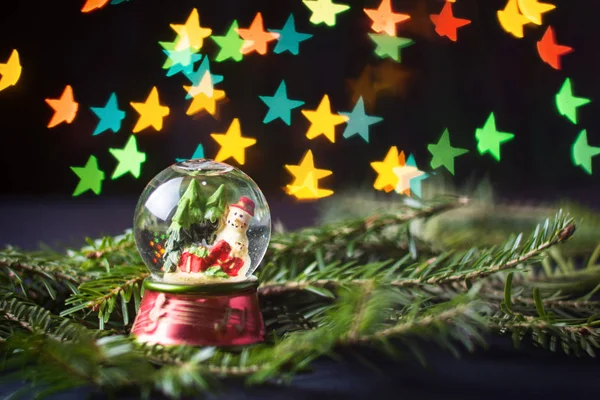 Boule de verre avec bonhomme de neige et bokeh en forme d'étoile — Photo