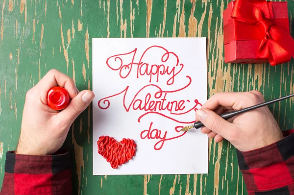 Uomo scrivere un biglietto di San Valentino e preparare regalo — Foto Stock