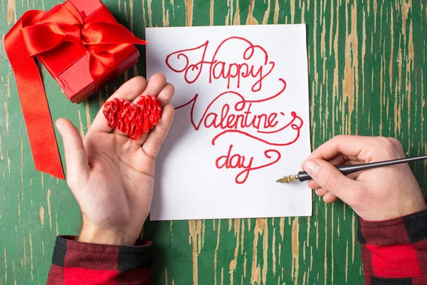 Mannelijke handen schrijven een Valentines day card — Stockfoto