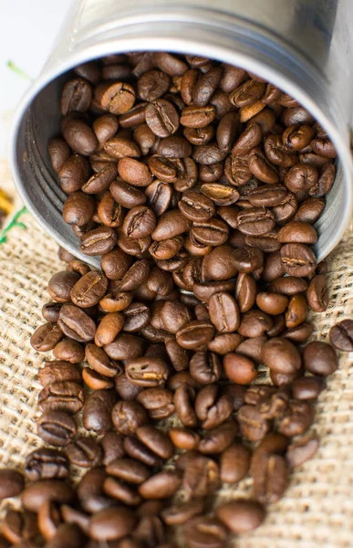 Granos de café tostados cayendo de metal puede — Foto de Stock