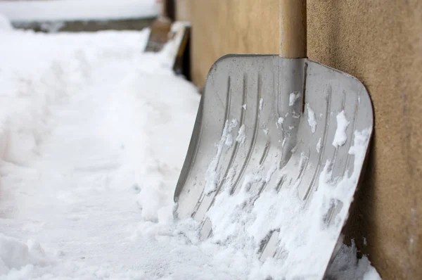 Snow shovel in snowed front yard — Stock Photo, Image