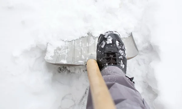 Using a snow shovel in a snowed yard — Stock Photo, Image