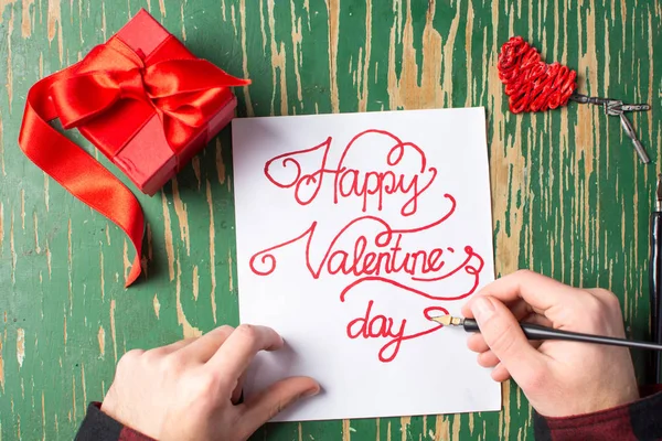Man schrijven een Valentijnsdag kaart en voorbereiding aanwezig — Stockfoto