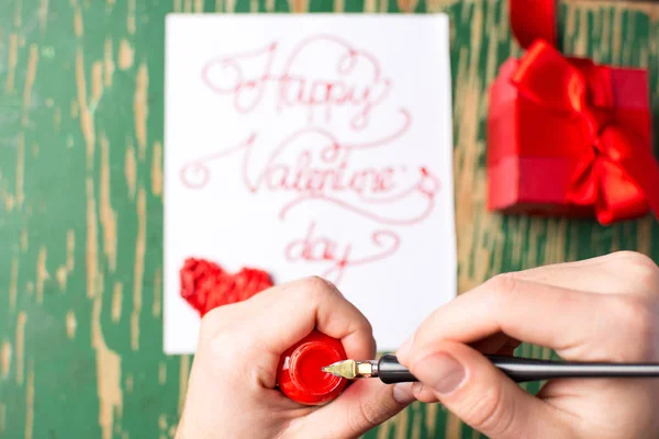 Man schrijven een Valentijnsdag kaart en voorbereiding aanwezig — Stockfoto