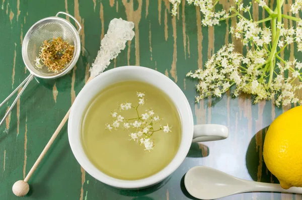 Elderflower tea in white cup and elder flowers — Stock Photo, Image