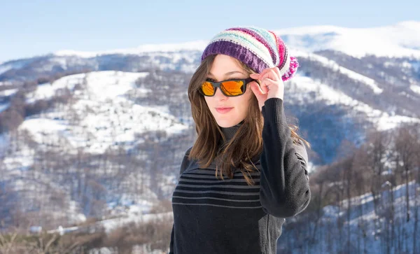 Menina com óculos de sol em uma montanha nevada — Fotografia de Stock