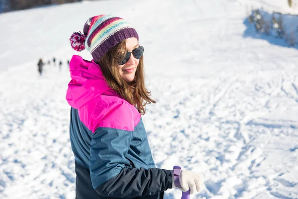 Fille avec des bâtons de randonnée sur la montagne enneigée — Photo