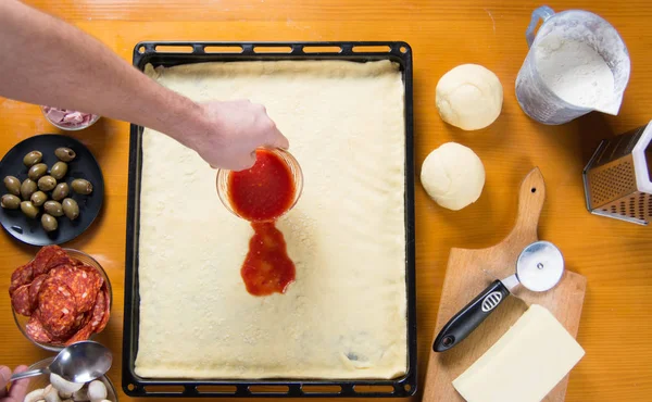 Seseorang menaruh saus tomat di piza — Stok Foto