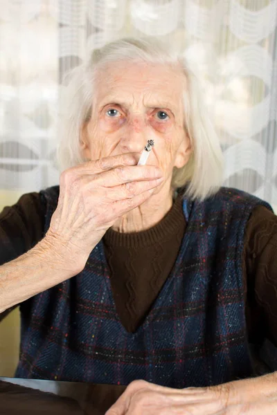 Seniorin raucht eine Zigarette — Stockfoto
