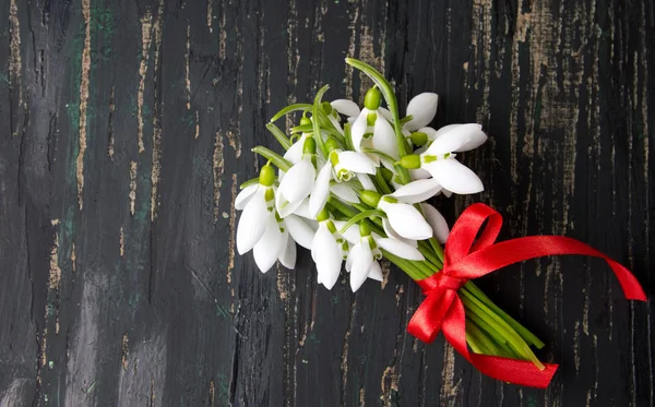 Snowdrops bouquet on dark wooden table — Stock Photo, Image
