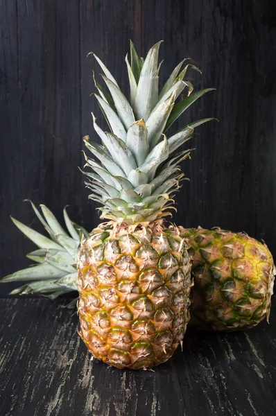 Fruta de abacaxi contra fundo de madeira escura — Fotografia de Stock