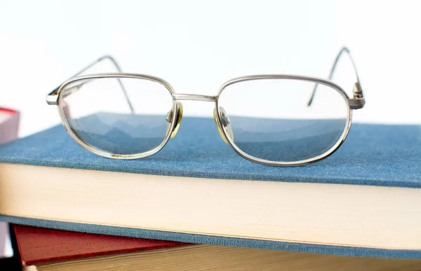 Läsglasögon ovanpå bok — Stockfoto