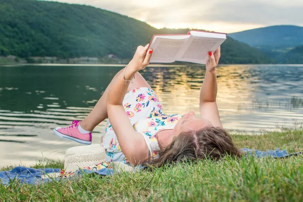 Kadın göl kenarında bir kitap okuma. Solo gevşeme — Stok fotoğraf