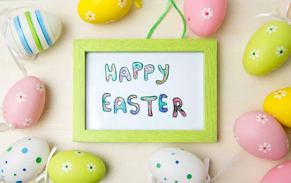 Cartão de Páscoa feliz em uma armação com ovos coloridos — Fotografia de Stock