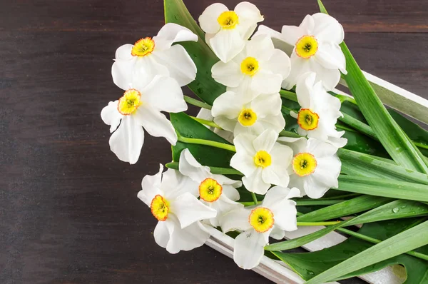 Narciso ramo de flores en una cesta de madera —  Fotos de Stock