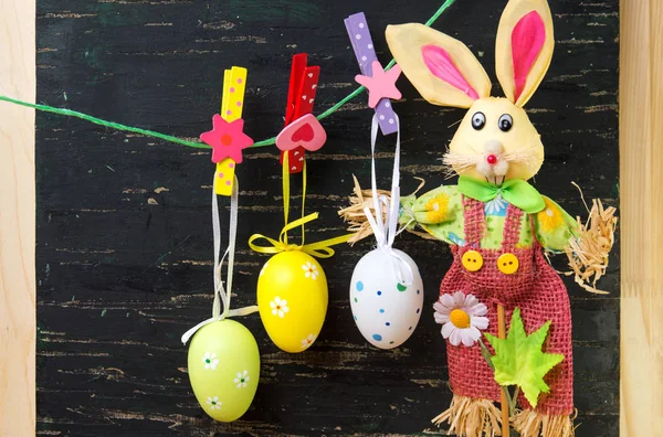 Huevos de Pascua colgando de una cuerda y un conejo —  Fotos de Stock