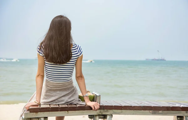 Flickan tittar på horisonten som sitter på en bänk — Stockfoto