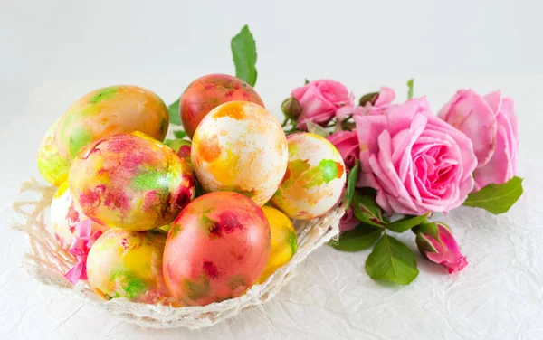 Velikonoční vajíčka a kytice růžových růží — Stock fotografie