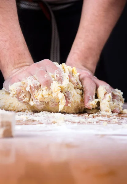 Мужчина пекарь смешивает тесто на крытом мукой столе — стоковое фото