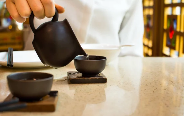Té femenino vertiendo en taza de té de cerámica — Foto de Stock
