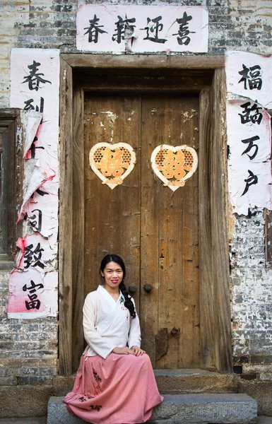 Chica sentada en frente de viejas puertas chinas —  Fotos de Stock