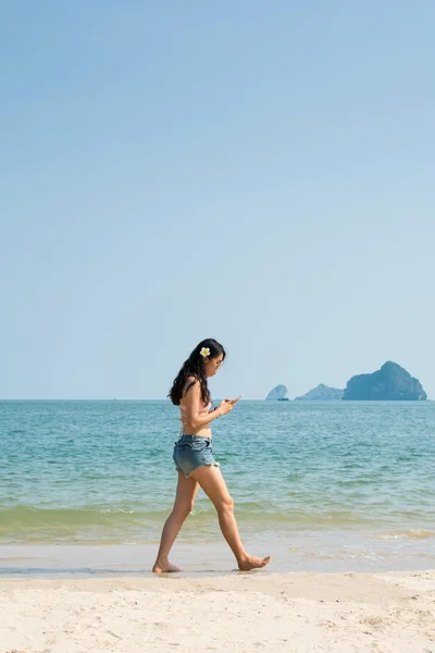 Girl looking at smart phone  on the beach — Stock Photo, Image