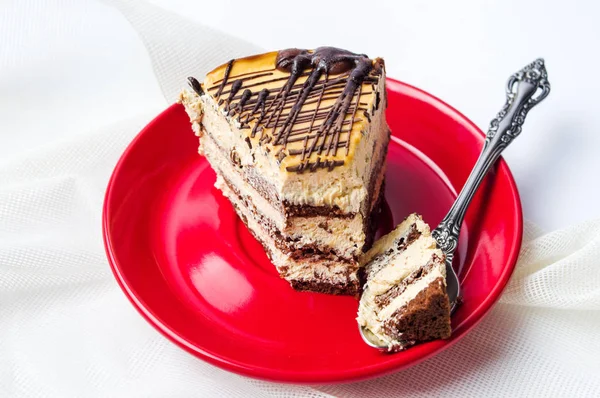 Karamell-Schokoladenkuchenscheibe auf rotem Teller — Stockfoto