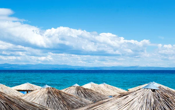 Straw umbrellas on the beach — Stock Photo, Image