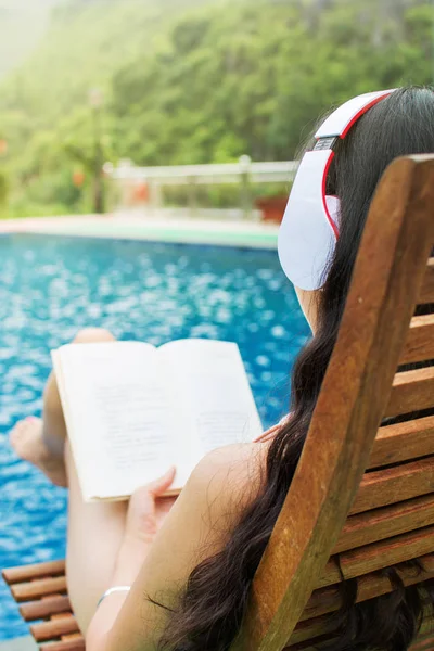 Menina lendo um livro na piscina — Fotografia de Stock