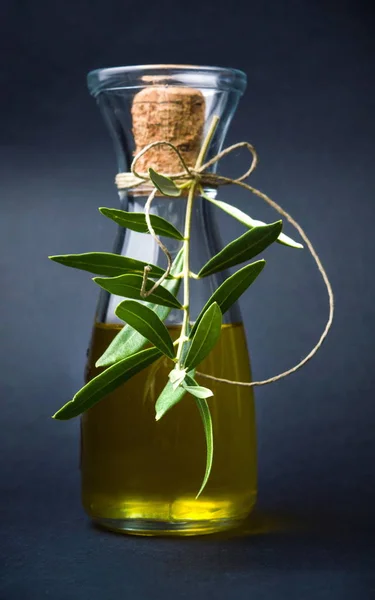 Пляшка оливкової олії на темному фоні — стокове фото